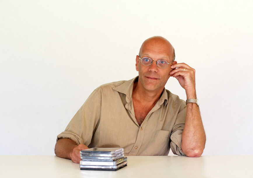 Geert leans to his left while sitting at a table.