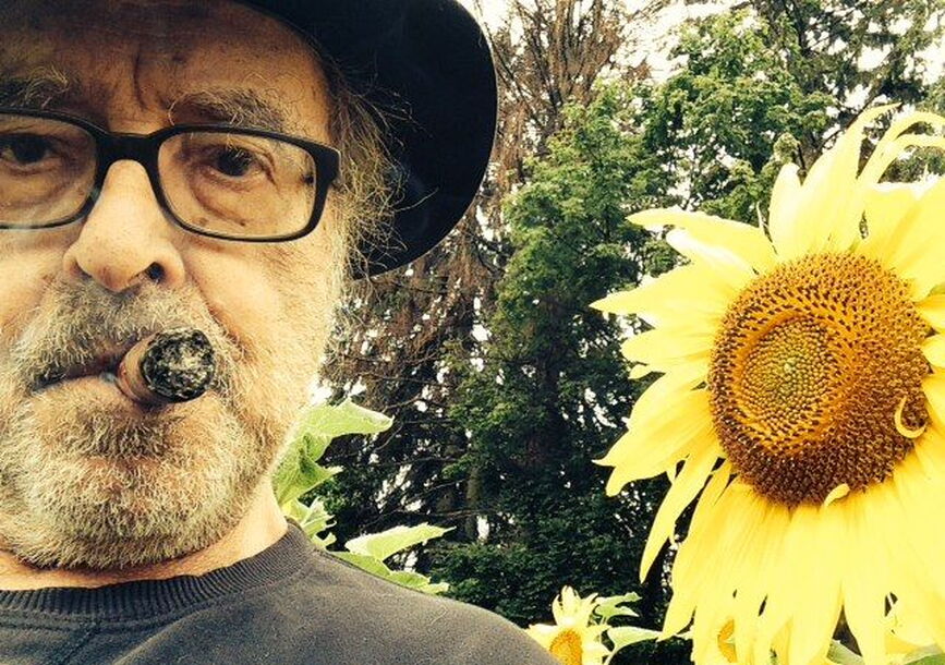 Jean-Luc is side by side with a sunflower.