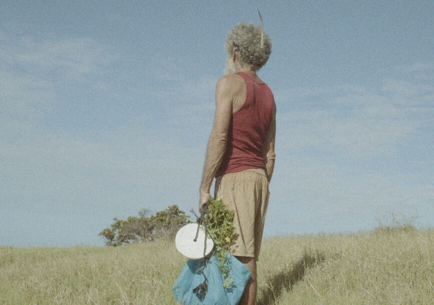 A person looks away in a field.